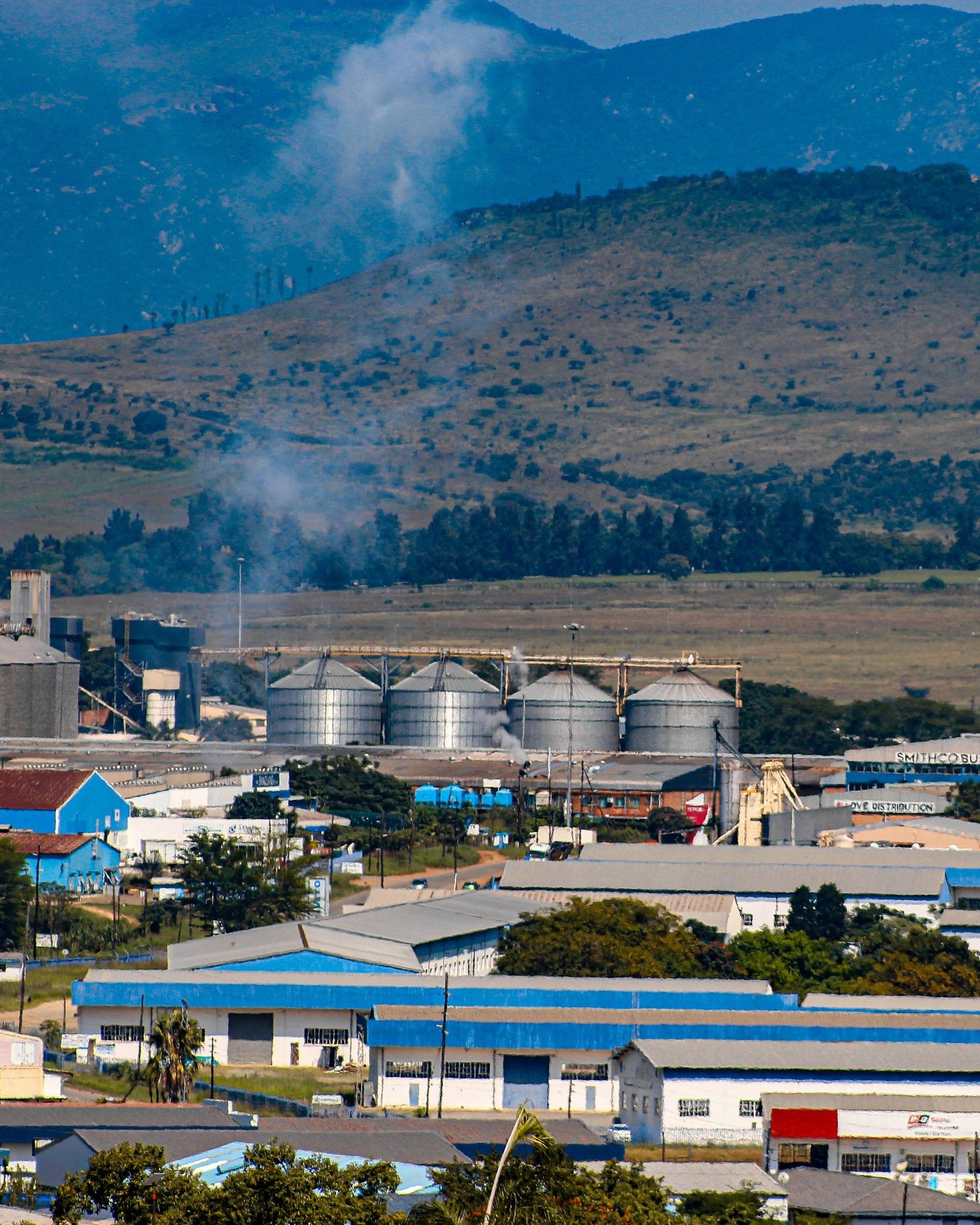 Industrial estate with silos, warehouses and factories below hills in Eswatini